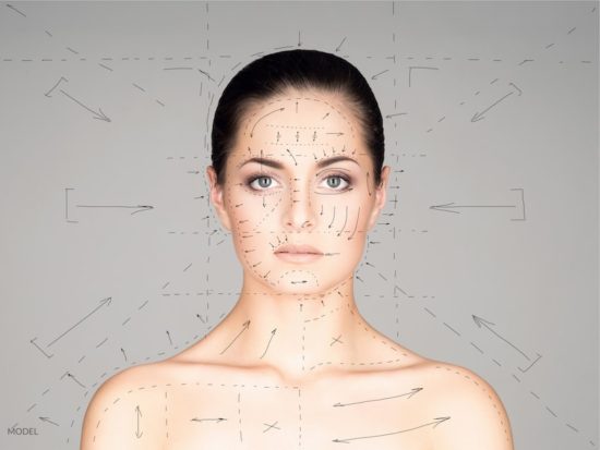 Young woman with lines drawn around and on her face. Cosmetic surgery concept.