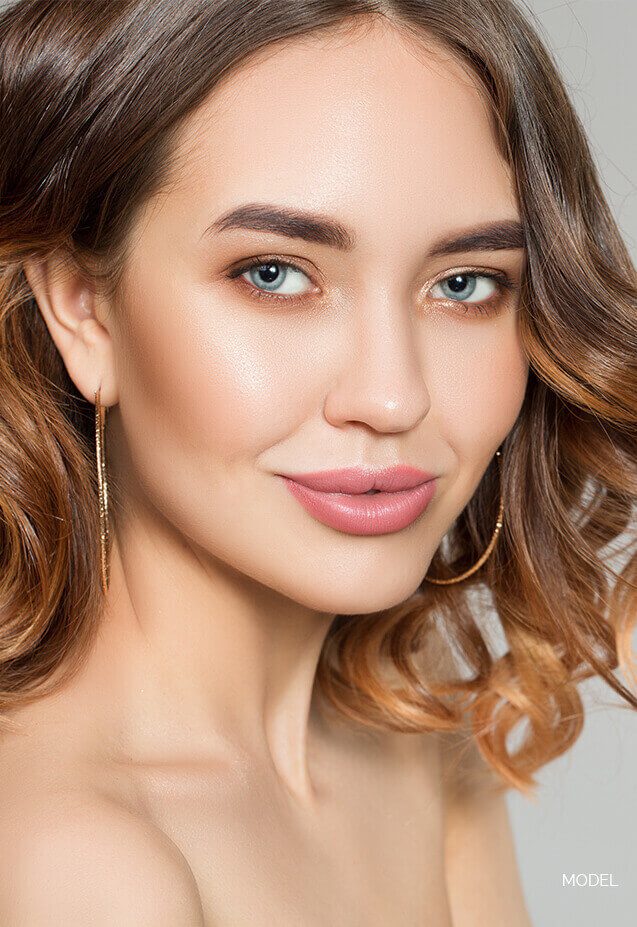Headshot of a female model with short wavy hair and bright eyes
