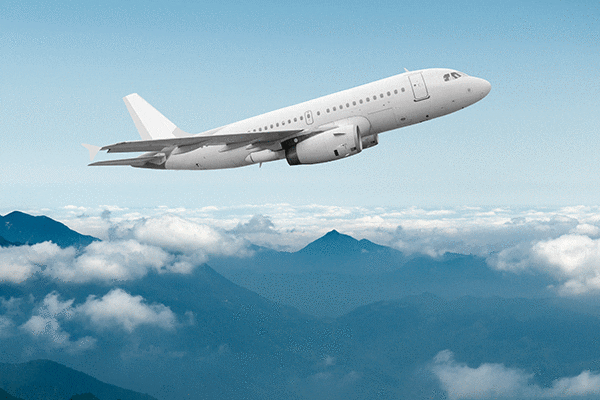 An airplane rising into the sky above the clouds