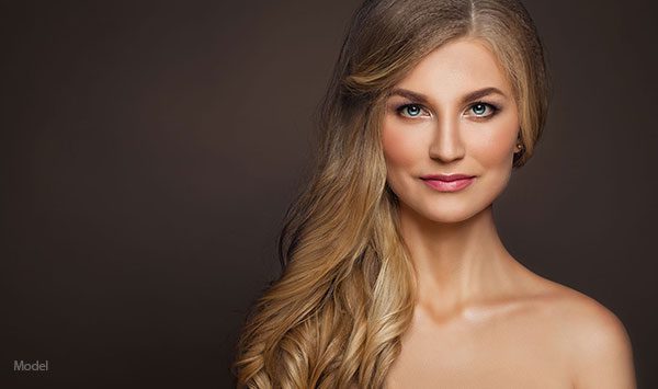 Headshot of a female model with her long hair brushed to one side over her shoulder