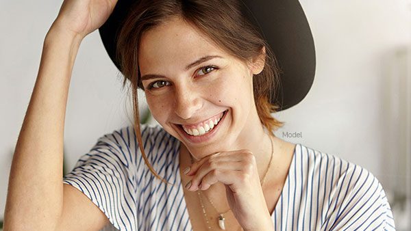 Young adult woman in a brim hat and stripped shirt