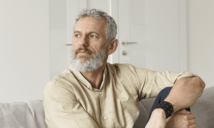 middle aged man sitting on a couch looking to the side