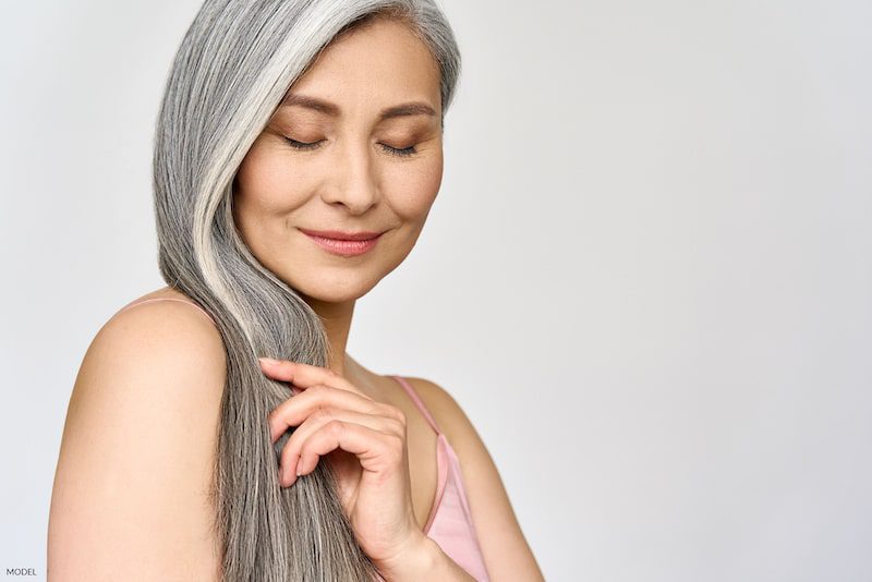 Beautiful older woman shows off her pretty long, gray hair.
